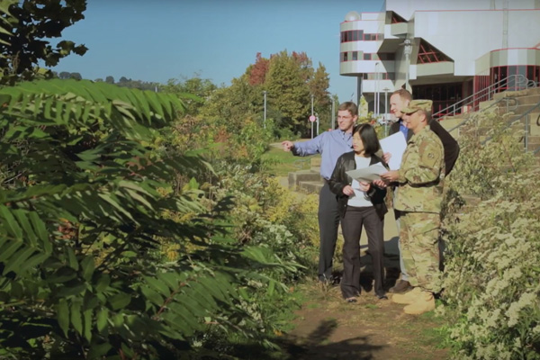 Vivien Li (center) discusses North Shore riverbank improvements with Colonel Lloyd (right) of the Army Corps. Photo by Uppercut Studios.