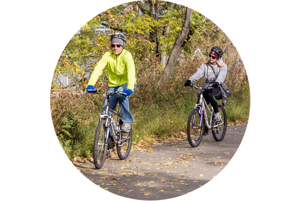 Two people riding bikes on a riverfront trail