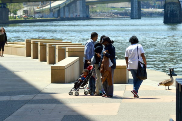 A family enjoys a sunny day at the Convention Center Riverfront Plaza