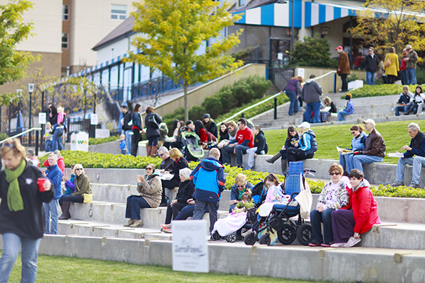 People gather on the steps and the Hofbrauhaus beer garden at South Shore Riverfront Park