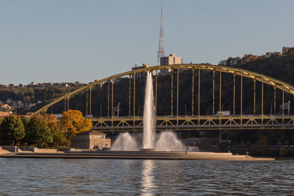 View of the fountain running during the fall season with Fort Pitt Bridge in background