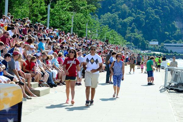 Riverfront bleacher steps packed with people at the Regatta on a sunny day.