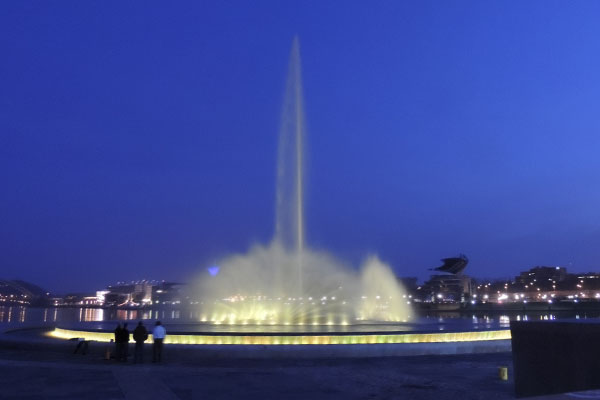 Fountain at dusk with white lights shining around the base