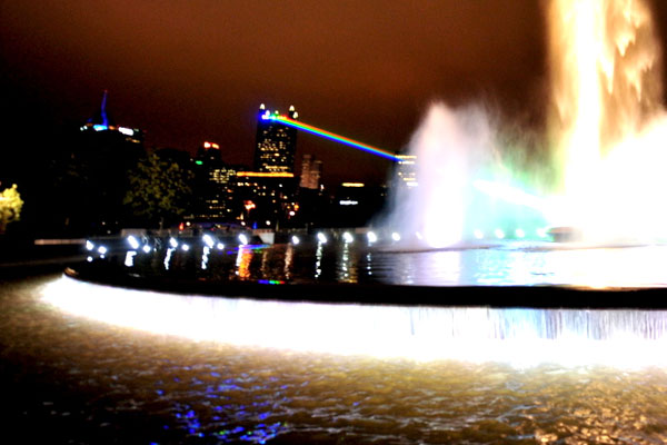 Nightime picture of the reflecting pool of the fountain with colorful lights