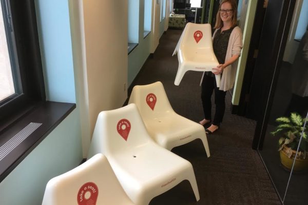 Riverlife Senior Project Manager Nina Chase prepares the chairs for their debut on the riverfront. They've been patiently stacked at the Riverlife offices.